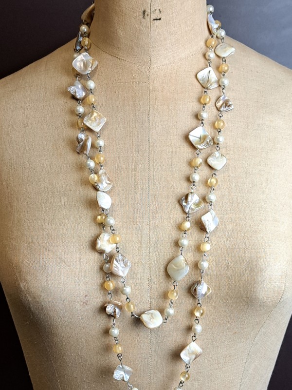 Lange parelmoer halsketting met onregelmatige schelpkralen.